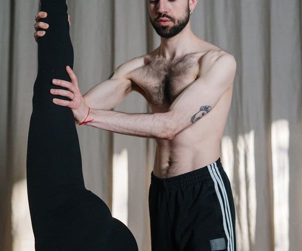 Instructor carefully guiding a person on proper exercise form.